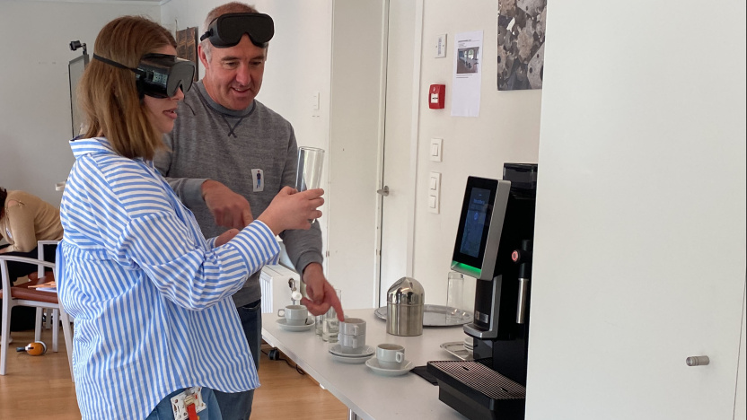 Twee medewerkers ervaren hoe het is om met een beperkt zicht een glas water in te schenken